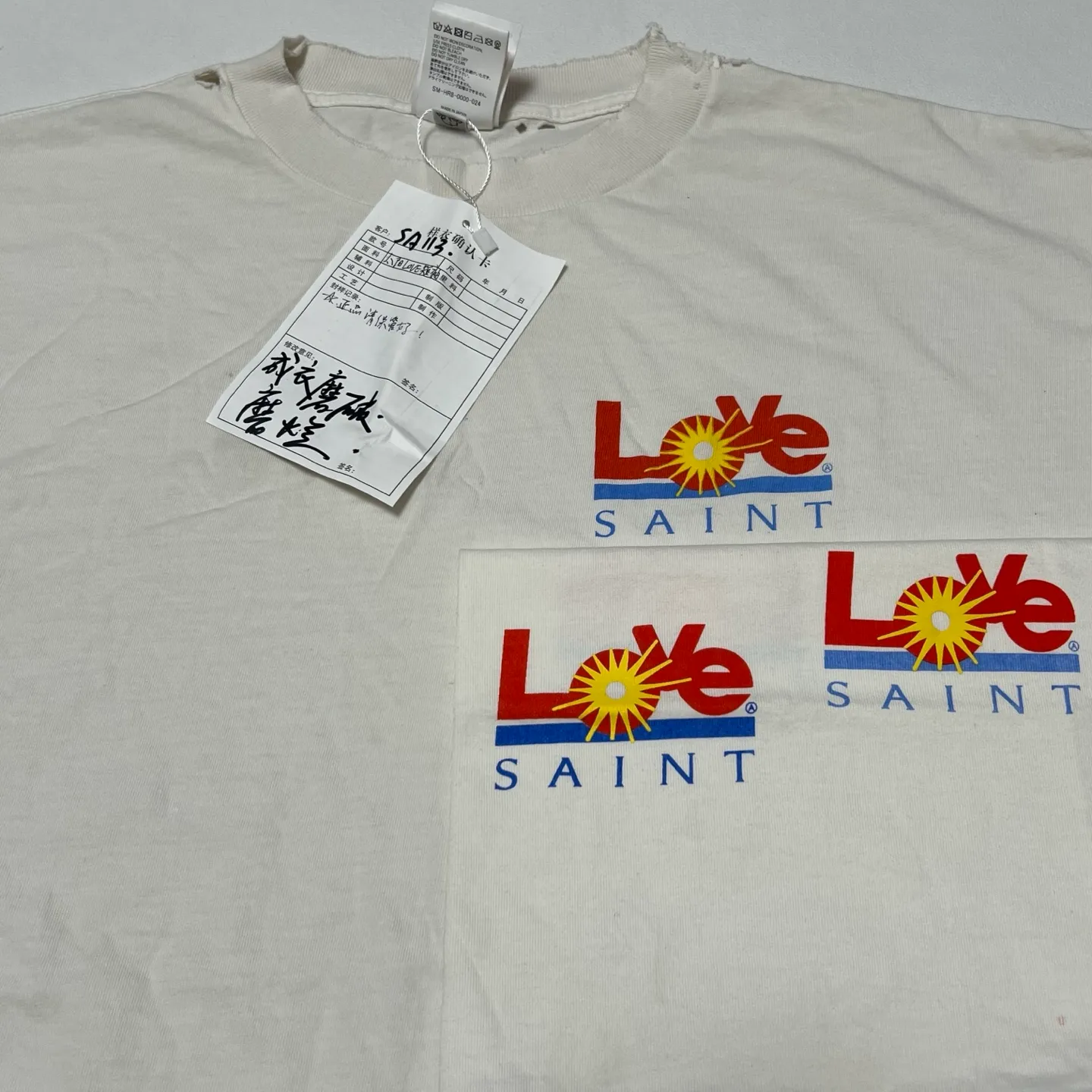 Printing and proofing comparison SAINT Mxxxxxx 25SS LOVE_SS TEE/WHT LOVE little sun damaged washed distressed short sleeves off-white S-XL rainbow OE yarn original consistent tube woven side seam fabric re-washed distressed process cut and destroyed holes processing hand-made graffiti splash ink original consistent main mark/wash mark/little angel anti-counterfeiting mark